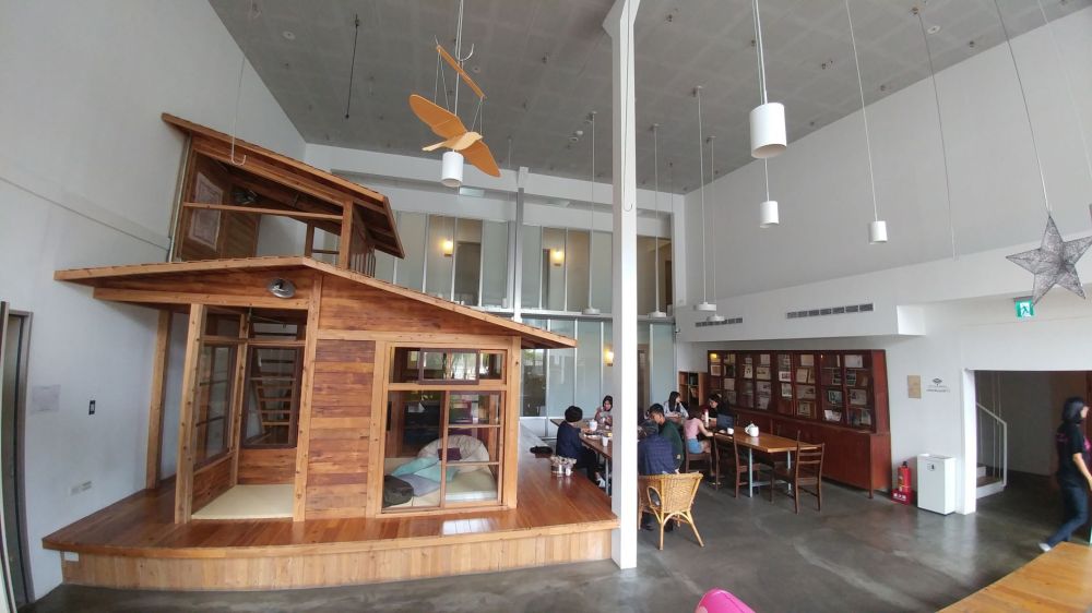 Überblick über den Aufenthaltsraum im Star Hostel Taipei Main Station. Holzhaus mit 2 Stockwerken!